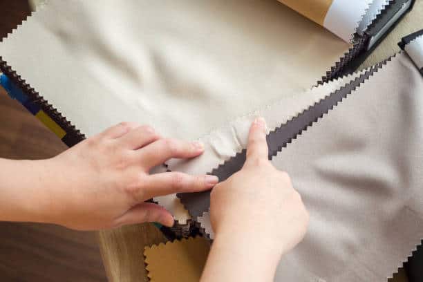 female designer with fabric color samples choosing textile for curtains